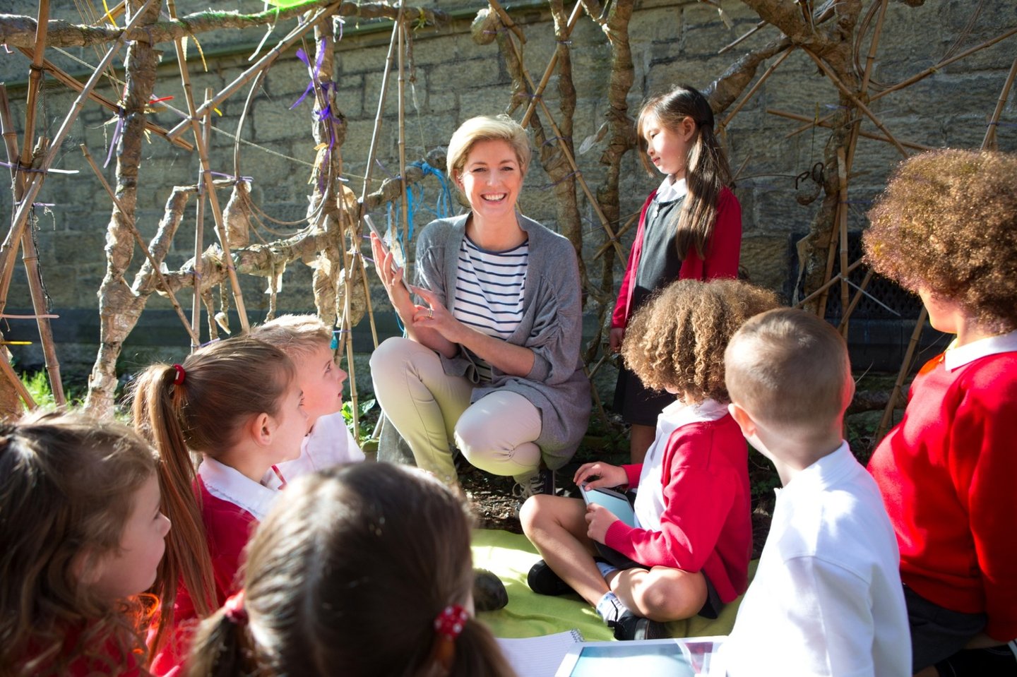A teacher sitting outdoors with a group of students